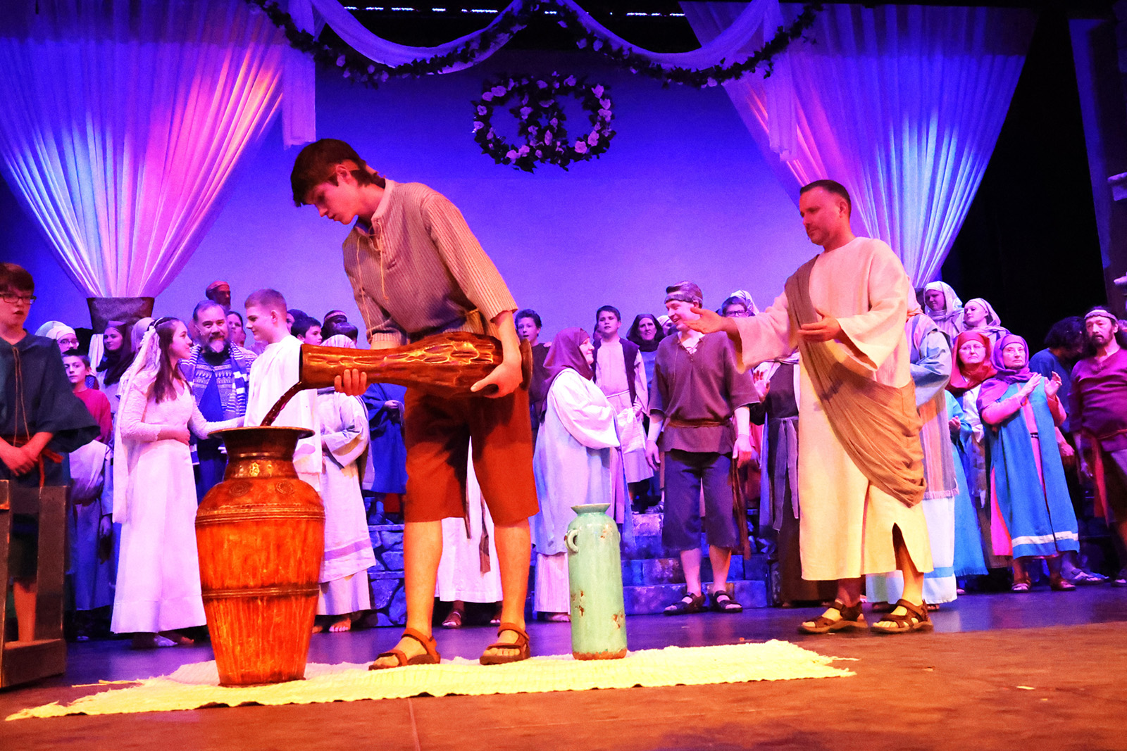 A steward pours wine as Jesus looks on.